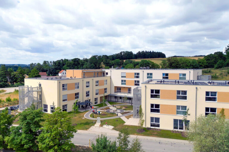 Moderne Betreuungseinrichtung am Standort Moosthenning mit gepflegtem Außenbereich.