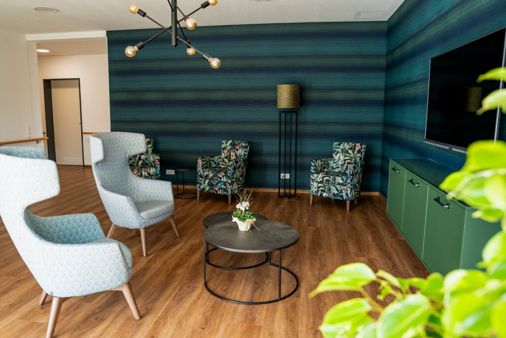 Moderne und gemütliche Inneneinrichtung des Pflegeheims in Stetten am kalten Markt mit farbenfrohen Sitzgelegenheiten.