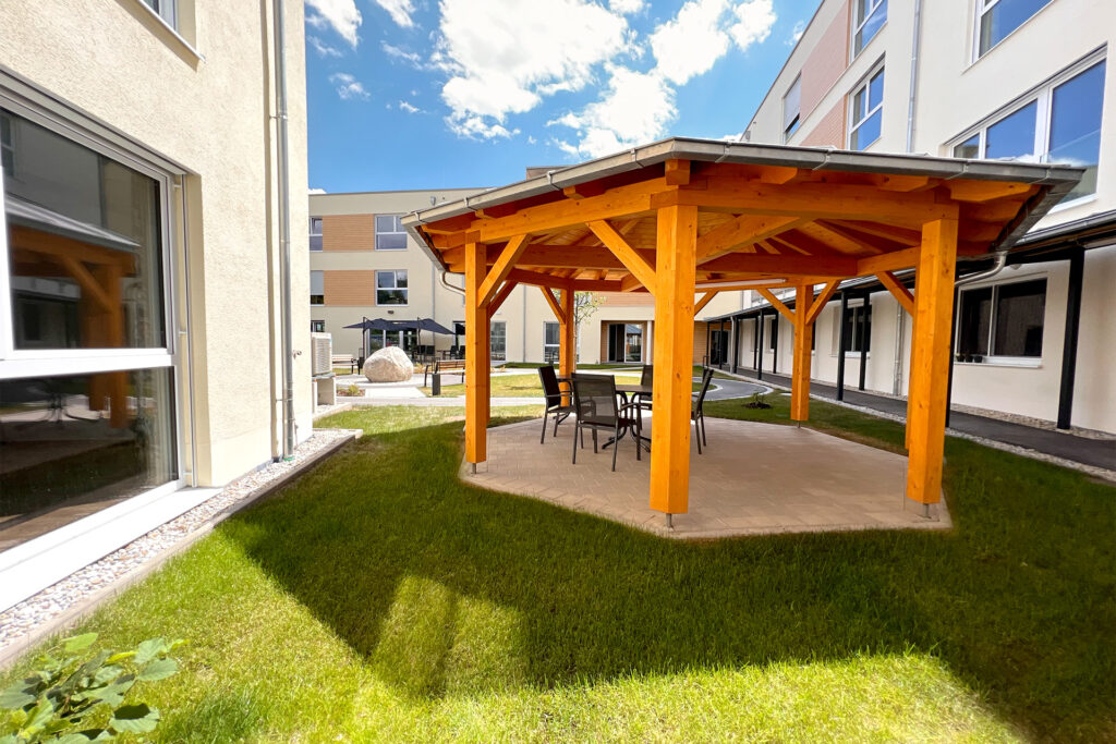 Pflegeeinrichtung in Moosthenning mit Außenbereich, Sitzecke und Pavillon für entspannte Aufenthalte im Freien.