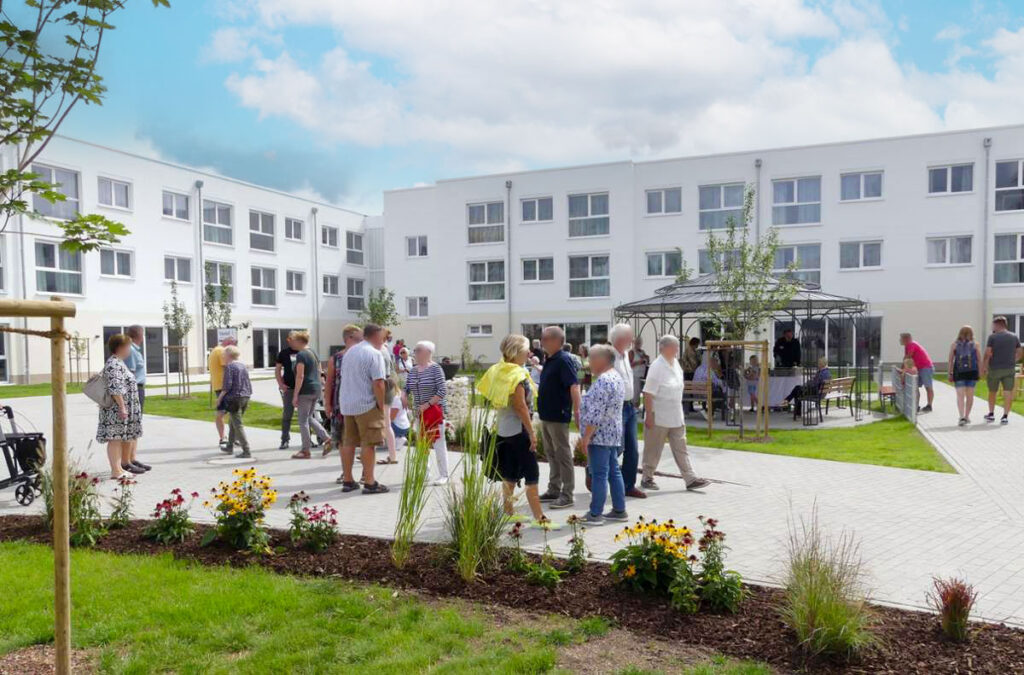 Pflegeheim-Außenbereich: Bewohner und Besucher bei einem gemeinschaftlichen Treffen im Garten der Einrichtung in Stetten.